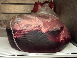 Busta di plastica contenente della carne non ben specificata immersa quasi totalmente nel sangue Busta di plastica contenente della carne non ben specificata immersa quasi totalmente nel sangue