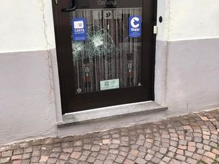 La vetrina della porta d'ingresso della Bookeria dopo l'atto vandalico (Foto Facebook Cinzia Grande).