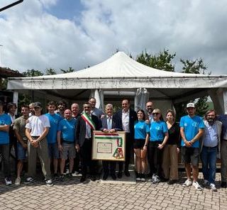 Il sindaco di Sinio Enzo Capra consegna all'ex primo cittadino Sergio Seghesio un quadro contenente la sua fascia di sindaco e una pergamena con una speciale dedica