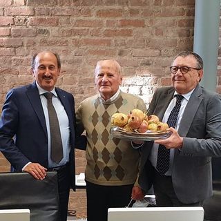 Pietro Bongiovanni, al centro, consegna il simbolico omaggio al presidente di Banca d'Alba Tino Cornaglia (a destra) e al direttore generale Riccardo Corino