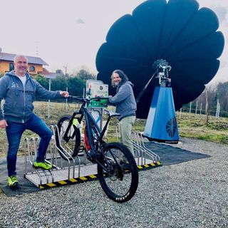 A sinistra, Francesco Beltrami accanto a una colonnina di ricarica ‘standard’ di Etraction (alimentata dall'energia green proveniente dallo SmartFlower installato tra i vigneti di Mezzomerico, nel Novarese).