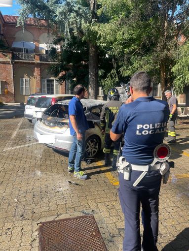 La Polizia Locale di fronte all'auto distrutta La Polizia Locale di fronte all'auto distrutta