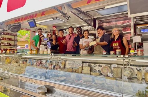 Turisti americani dietro al bancone di Michele al mercato di Buttigliera d'Asti Turisti americani dietro al bancone di Michele al mercato di Buttigliera d'Asti