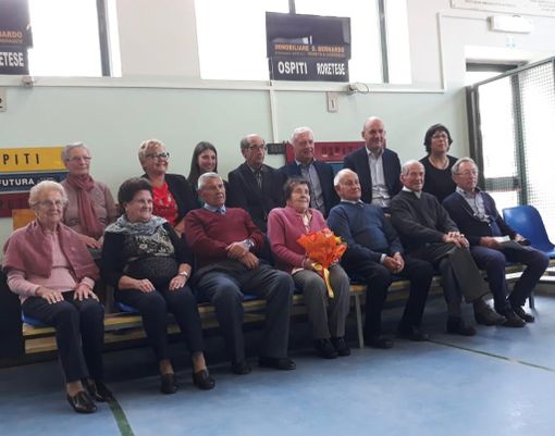Maria Torta, al centro della foto di gruppo con il mazzo di fiori omaggiatole durante la giornata di festa