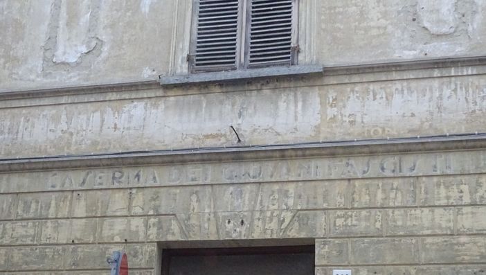 La scritta “Caserma dei giovani fascisti” sul muro di un palazzo nel centro storico di Bra