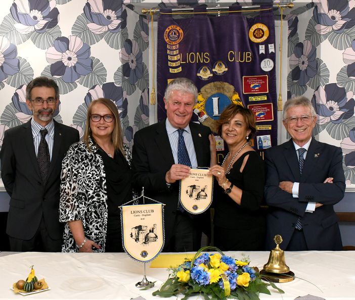 Il presidente Carla Blengio consegna il gagliardetto del Lions Club Carrù-Dogliani al presidente di zona, Teresio Cavallo. Con lei, il past president, Raffaele Sasso, il cerimoniere Paola Porta e il tesoriere, Paolo Navello