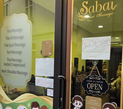 La vetrina del negozio albese, con l'esplicito cartello La vetrina del negozio albese, con l'esplicito cartello