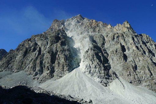 Il canalone e il cono detritico visti dal sentiero per il colle di Viso e il rifugio Quintino Sella: è visibile la polvere in sospensione dovuta ai continui distacchi di pietre ancora in corso (foto Arpa Piemonte)