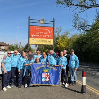 I giocatori dell'Over 50 Football Club Provincia Granda con la bandiera della Provincia per le strade di Manchester