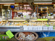 La struttura di vendita dei formaggi di Michele e Pierangela con i cartelli &quot;Su questo banco si parla anche piemontese&quot;