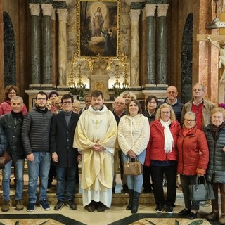 In foto don Enzo Torchio e un coro del Santuario al fianco della Madonna Nera