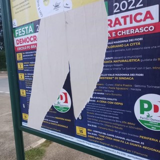 Nella foto i manifesti strappati che annunciano la festa democratica 2022, a Bra