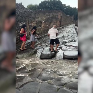 Acquazzone su Pompei, turisti usano le antiche strisce pedonali dei romani